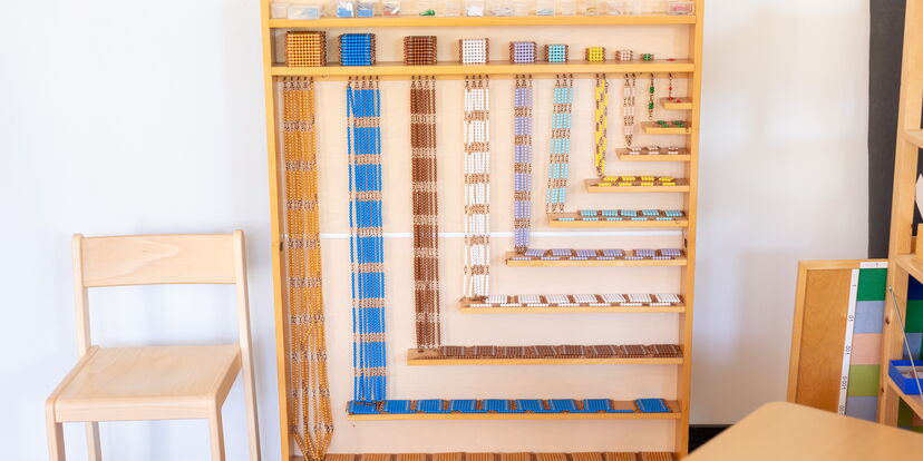 Perlenregal aus Holz mit buntem Perlenmaterial zur Multiplikation.