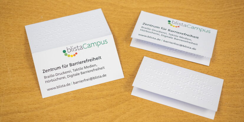 Eine Klapp-Visitenkarte mit Schwarz- und Punktschrift.