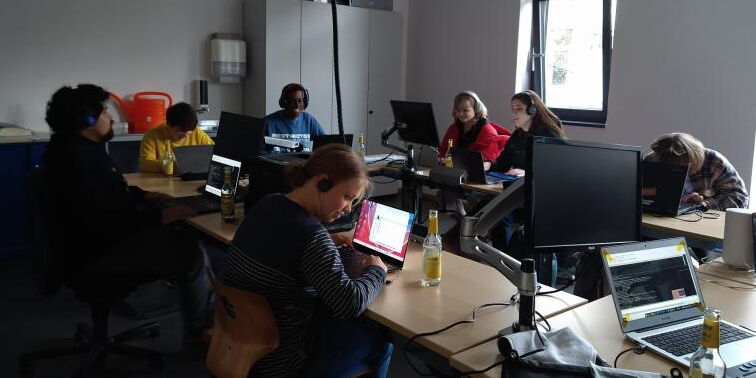 Im Multifunktionsraum sitzen Schüler*innen mit Kopfhörern konzentriert an Rechnern und zocken.