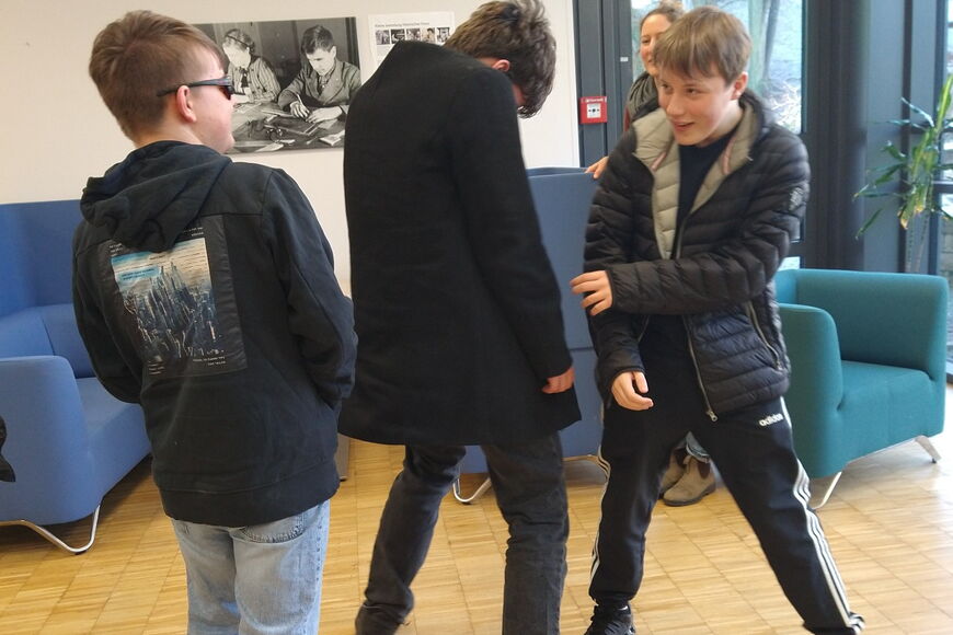 Im Workshop „Unschlagbar auftreten" machen drei Schüler eine Übung zum Thema selbstbewusstes Auftreten.