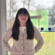 Portraitfoto Leonie Pöltl - sie hat langes braunes Haar und trägt eine Brille.