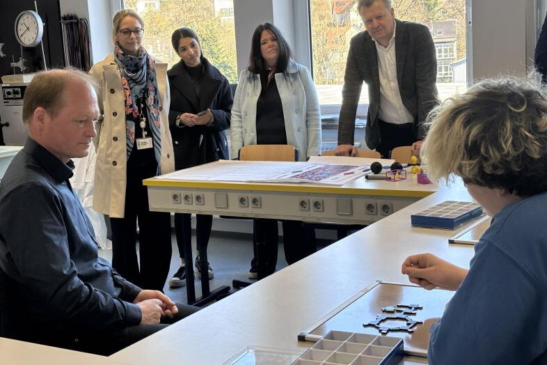 Die Gäste schauen sich an, wie ein Schüler ein Multimediales Lernpaket Chemie nutzt.