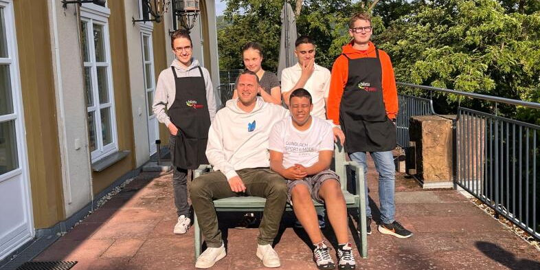 Gruppenbild: 6 Teilnehmende des blista Dinners, zwei von ihnen tragen schwarze Kochschürzen mit dem blista-Logo.