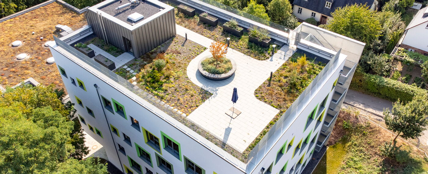 Das Schulgebäude der Montessorischule mit Dachterasse von oben.