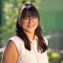 Portraitfoto Leonie Pöltl - Sie trägt langes dunkles Haar mit Pony, eine Brille und eine helle Bluse.