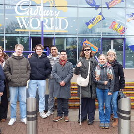 Die 6 Teilnehmenden der Englandfahrt mit ihren Lehrkräften stehen vor dem Eingang der Cadbury World